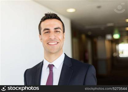 business and people concept - businessman in suit at corridor in hotel. businessman in suit at hotel corridor