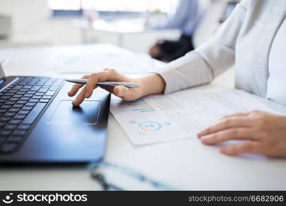 business and people concept - businesswoman with laptop computer and papers working at office. businesswoman with laptop working at office