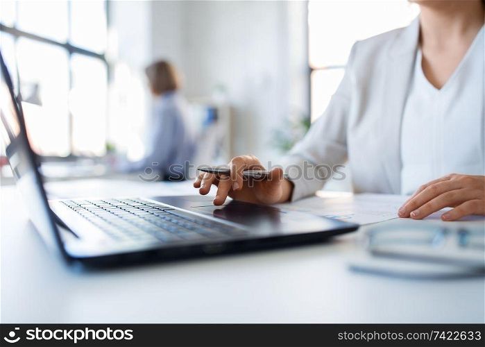 business and people concept - businesswoman with laptop computer and papers working at office. businesswoman with laptop working at office