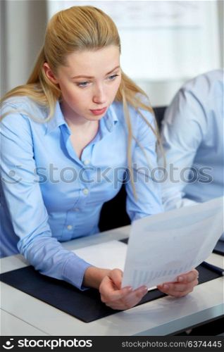 business and people concept - businesswoman with papers working at office. businesswoman with papers working at office
