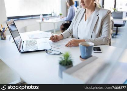 business and people concept - businesswoman with papers working at office. businesswoman with papers working at office