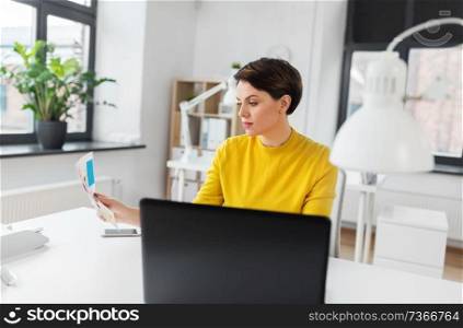 business and people concept - businesswoman woman or designer with laptop computer working at office. businesswoman woman with laptop computer at office