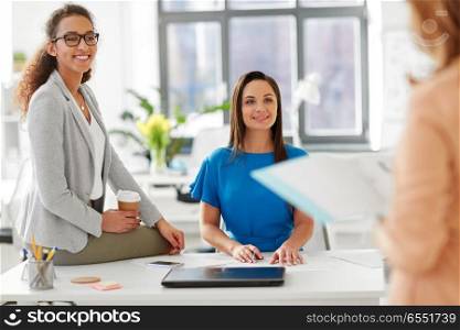 business and people concept - businesswomen listening to colleague at office presentation. businesswomen at presentation in office. businesswomen at presentation in office