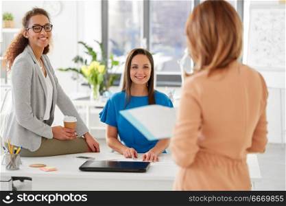 business and people concept - businesswomen listening to colleague at office presentation. businesswomen at presentation in office. businesswomen at presentation in office