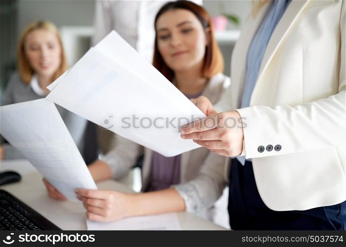 business and people concept - businesswomen with papers in office. businesswomen with papers in office