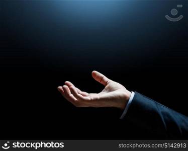 business and people concept - close up of businessman empty hand over dark background. close up of businessman hand over black