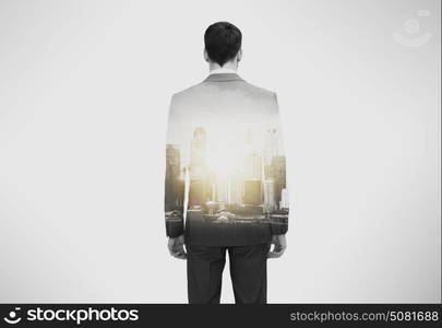 business and people concept - close up of businessman in suit from back over city buildings and double exposure effect. close up of businessman in suit from back