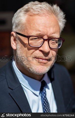 business and people concept - close up of senior businessman in eyeglasses and suit. close up of senior businessman in eyeglasses