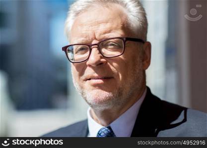 business and people concept - close up of senior businessman in eyeglasses and suit. close up of senior businessman in eyeglasses
