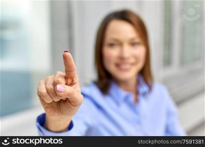 business and people concept - close up of smiling businesswoman touching something with finger. businesswoman touching something with finger