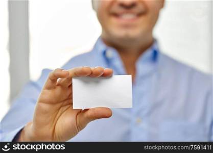 business and people concept - close up of smiling man holding empty white card. close up of smiling man holding business card