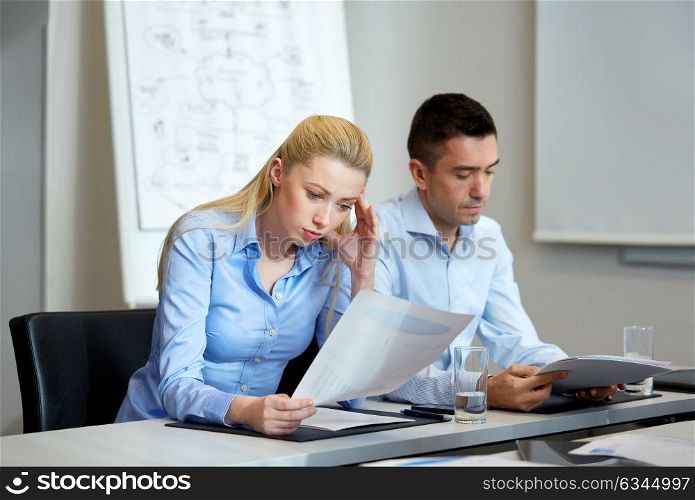 business and people concept - colleagues with papers working at office. business people with papers working at office