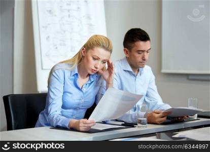 business and people concept - colleagues with papers working at office. business people with papers working at office