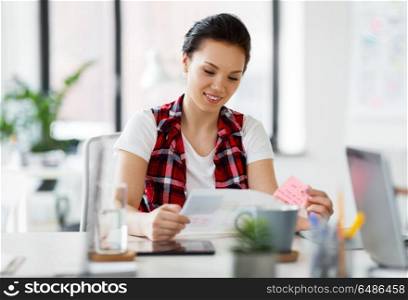 business and people concept - creative woman with papers working at office. creative woman with papers working at office. creative woman with papers working at office