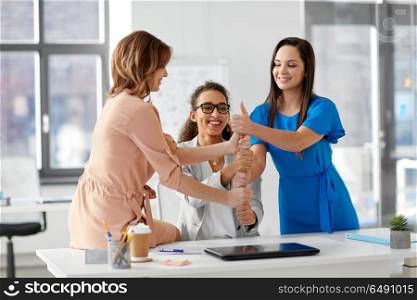business and people concept - group of businesswomen showing thumbs up at office. group of businesswomen showing thumbs up at office. group of businesswomen showing thumbs up at office