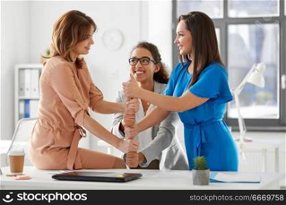 business and people concept - group of businesswomen showing thumbs up at office. group of businesswomen showing thumbs up at office. group of businesswomen showing thumbs up at office