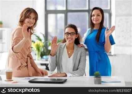 business and people concept - group of businesswomen waving hands at office. group of businesswomen waving hands at office. group of businesswomen waving hands at office