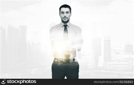 business and people concept - handsome businessman with crossed arms over city buildings and double exposure effect. handsome businessman with crossed arms