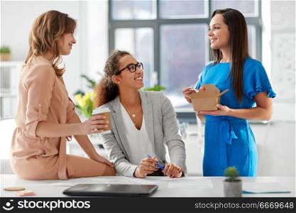 business and people concept - happy businesswomen having lunch or coffee break at office. businesswomen having lunch at office. businesswomen having lunch at office