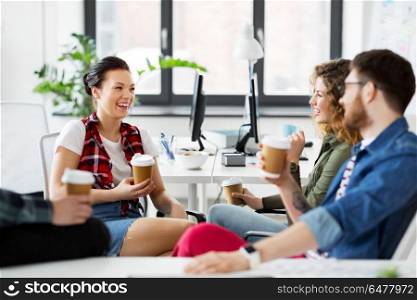 business and people concept - happy creative team drinking coffee at office. creative team drinking coffee at office. creative team drinking coffee at office