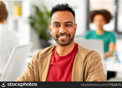 business and people concept - happy smiling indian man at office. smiling indian man at office