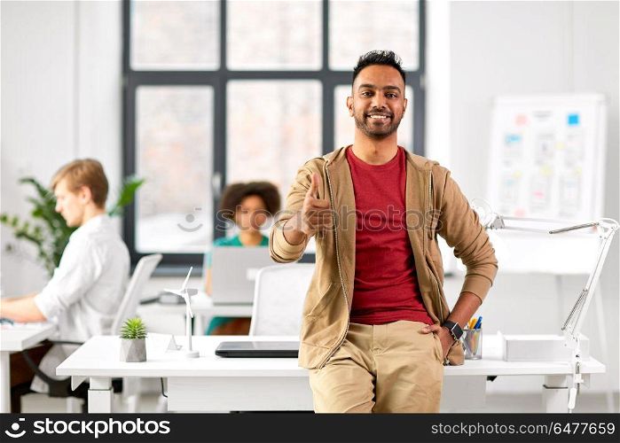business and people concept - happy smiling indian man showing thumbs up at office. smiling indian man showing thumbs up at office. smiling indian man showing thumbs up at office