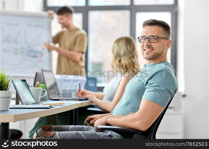 business and people concept - happy smiling man in glasses at office conference. happy smiling man in glasses at office conference