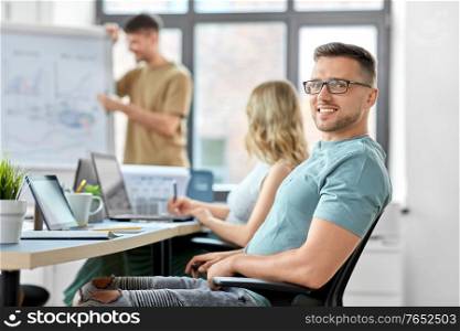 business and people concept - happy smiling man in glasses at office conference. happy smiling man in glasses at office conference
