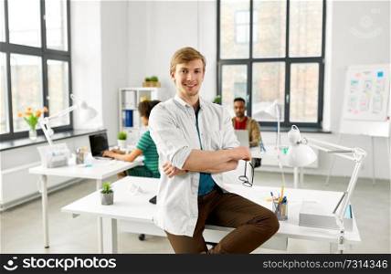 business and people concept - happy smiling man with glasses at office. happy smiling man with glasses at office