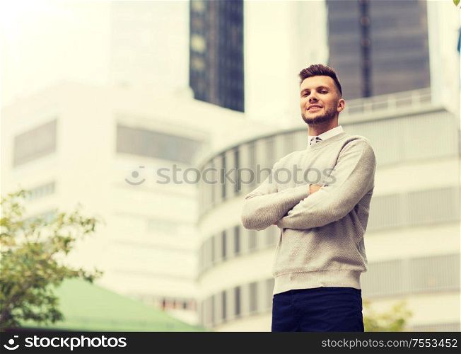 business and people concept - happy smiling young man on city street. young man on city street