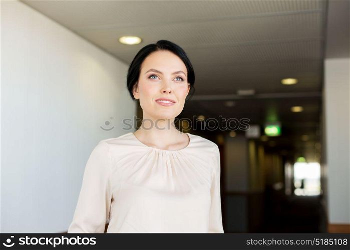business and people concept - happy woman at corridor in hotel. happy woman at corridor in hotel