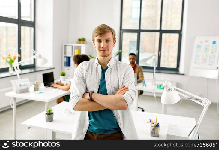 business and people concept - man with crossed hands at office. man with crossed hands at office