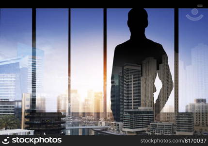 business and people concept - silhouette of business man over double exposure office and city background. silhouette of business man over city background