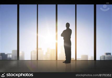 business and people concept - silhouette of business man over office window background. silhouette of business man over office background