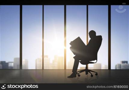 business and people concept - silhouette of businessman reading documents over office window background. silhouette of businessman reading documents