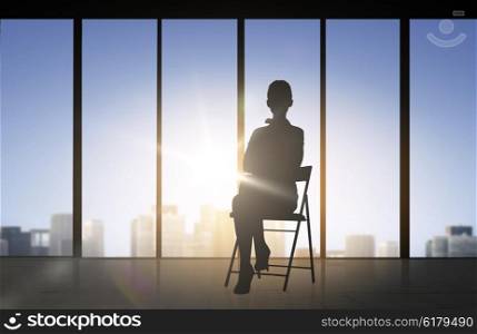 business and people concept - silhouette of woman sitting on chair over office window background. silhouette of business woman sitting on chair