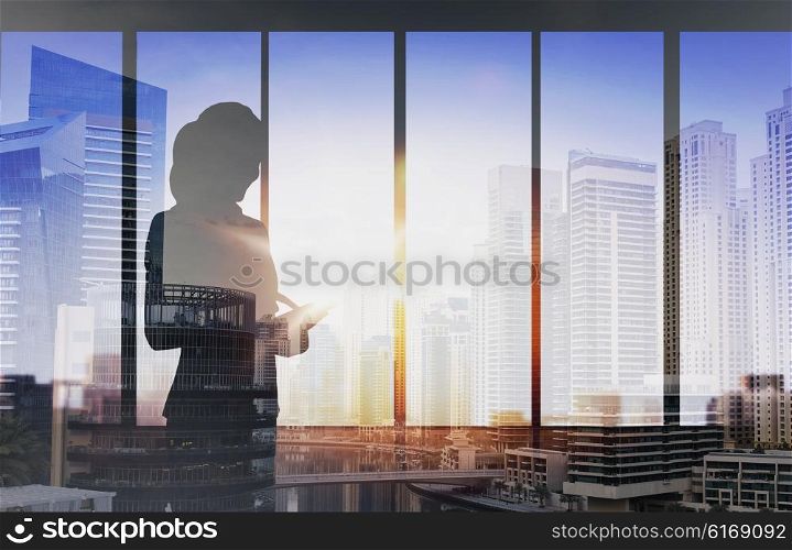 business and people concept - silhouette of woman with tablet pc over office window background over double exposure office and city background. silhouette of businesswoman with tablet pc