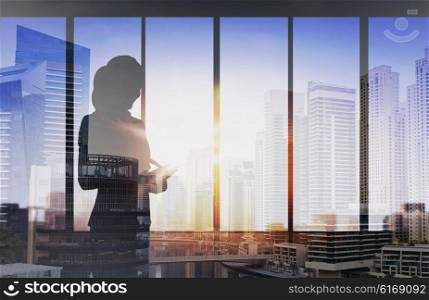 business and people concept - silhouette of woman with tablet pc over office window background over double exposure office and city background. silhouette of businesswoman with tablet pc