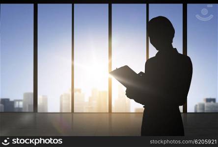 business and people concept - silhouette of woman with tablet pc over office window background. silhouette of business woman with tablet pc