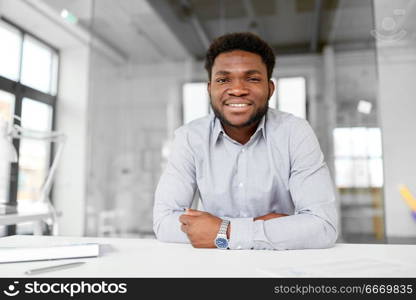 business and people concept - smiling african american businessman at office. smiling african american businessman at office. smiling african american businessman at office