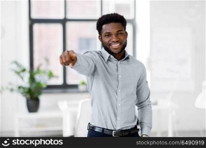 business and people concept - smiling african american businessman at office pointing at you. african businessman at office pointing at you. african businessman at office pointing at you