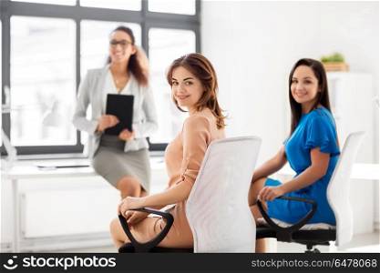 business and people concept - smiling businesswomen at meeting in office. businesswomen at business meeting in office. businesswomen at business meeting in office