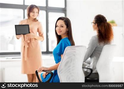 business and people concept - smiling businesswomen at meeting in office. businesswomen at business meeting in office. businesswomen at business meeting in office