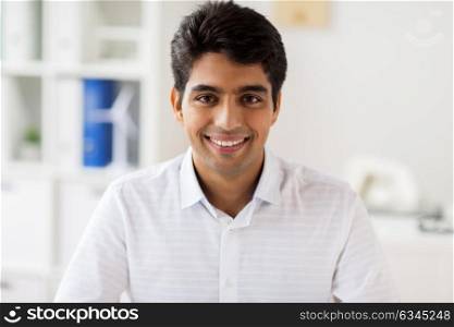 business and people concept - smiling indian businessman at office. smiling indian businessman at office
