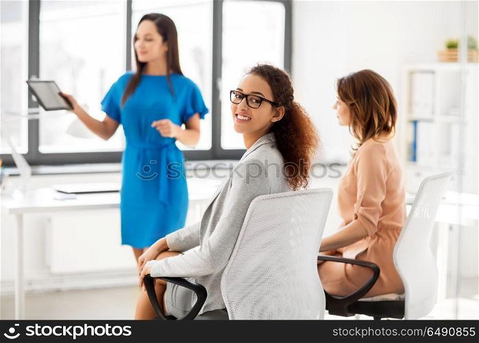 business and people concept - smiling woman at meeting in office. smiling woman at business meeting in office. smiling woman at business meeting in office