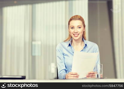 business and people concept - smiling woman holding papers in office. smiling woman holding papers in office