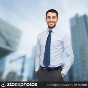 business and people concept - smiling young and handsome businessman over business centre background