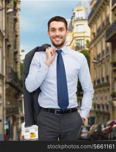business and people concept - smiling young and handsome businessman over old city background