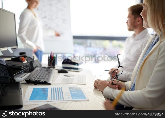 business and people concept - team at presentation in office. business team at presentation in office