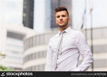 business and people concept - young man in shirt and tie on city street. young man in shirt and tie on city street